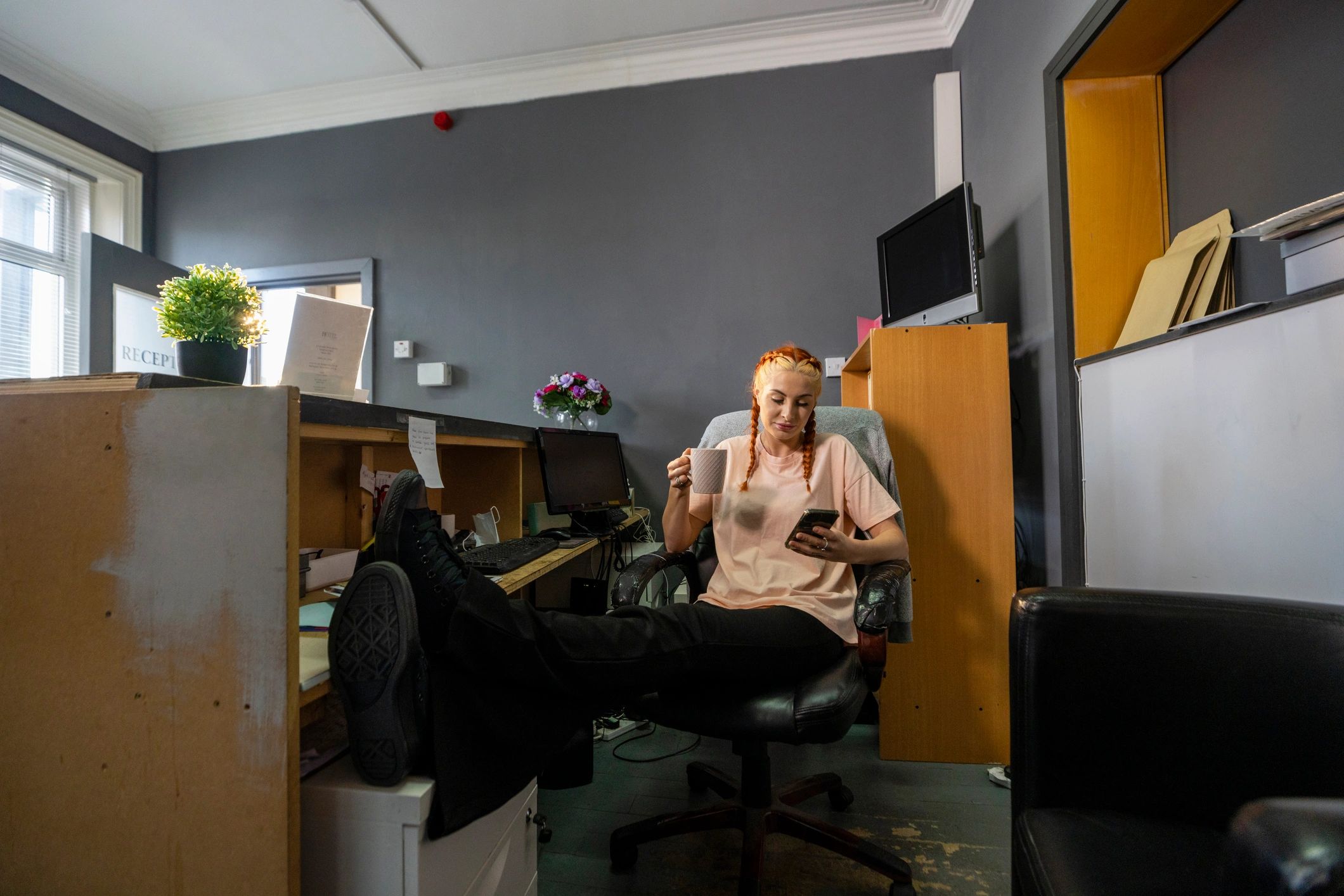 Person using a phone in a relaxed workspace